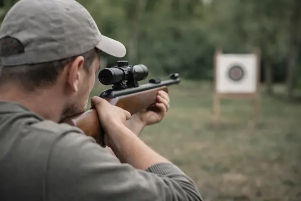 Muž strieľa zo vzduchovky na terč – praktické použitie kalibru 4,5 alebo 5,5 mm.webp