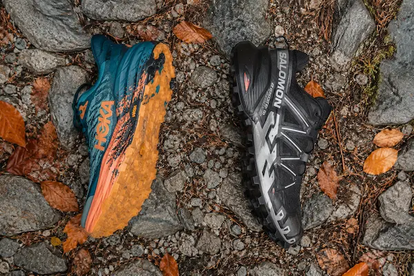 HOKA Speedgoat 7 a Salomon Speedcross 6 trail topánky – porovnanie podrážok na skalnatom teréne.webp